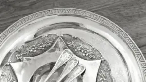 Dettaglio di un vassoio d'argento con cucchiaini decorativi su tavolo in legno