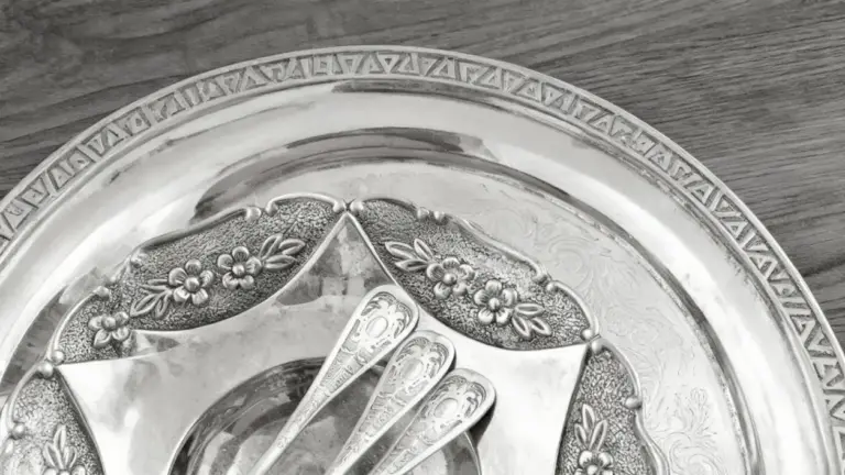 Dettaglio di un vassoio d'argento con cucchiaini decorativi su tavolo in legno